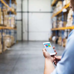man with mobile device in fulfillment warehouse